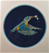 Kingfisher flying up with fish on dark blue silk